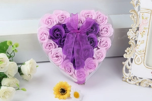 Close-up of heart-shaped gift box featuring pink and purple soap flowers with a bow