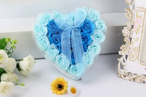 Close-up of heart-shaped gift box with blue soap roses and elegant ribbon bow