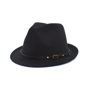 Detailed close-up of a black fedora hat with gold rivets on a leather decorative band