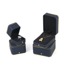 Detail view of dark blue jewelry gift box with gold trim for ring and necklace