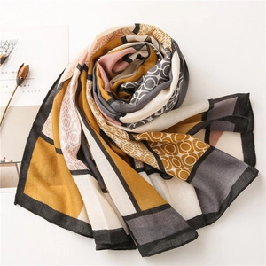 Detail of artistic geometric print scarf in ginger and grey on a minimalist background