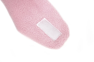 Dettaglio cappello in pile per neonati con texture morbida e chiusura a strappo bianca