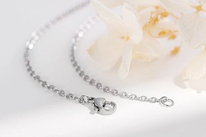 Macro detail of silver titanium steel O-chain necklace with a secure lobster clasp closure