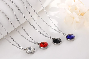 Detail of four stainless steel necklaces with sparkling zircon pendants in multiple colors
