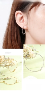 Detailed close-up of minimalist twisted rope earrings in gold and silver plating