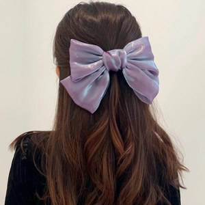 Dettaglio di un grande fermaglio per capelli a farfalla viola laser indossato sulla testa