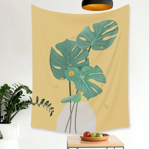 Close-up of Morandi plant tapestry with monstera leaves hanging in a modern living room