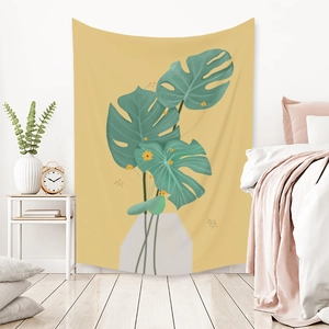 Detail of Morandi-style yellow tapestry with green monstera leaf in a cozy bedroom