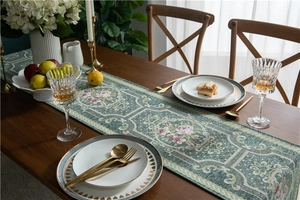Detail of green chenille table runner with pink floral jacquard and elegant tassels