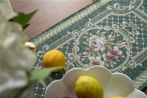 Detail of green chenille table runner featuring pink floral jacquard and thick texture