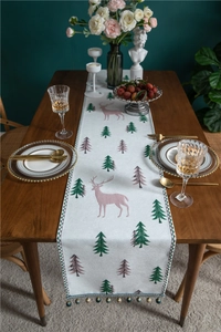 Detail of Christmas table runner with reindeer embroidery and elegant beaded fringe