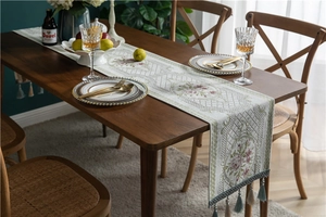 Detail of European jacquard table runner with purple roses and blue decorative tassels