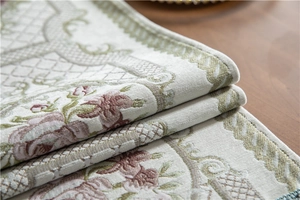 Macro view of textured chenille table runner featuring green and pink floral patterns