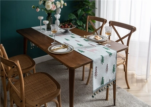 Detail of chenille table runner with pink elk and green tree embroidery and beaded tassels