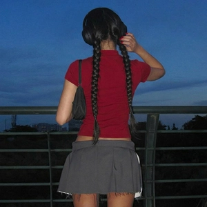 Style urbain avec crop top polo rouge et mini-jupe plissée avec un casque audio