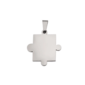 Détail macro d'un pendentif en forme de pièce de puzzle en acier poli miroir