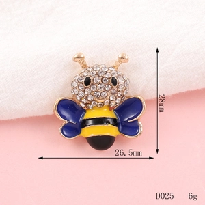 Detail view of a 28mm gold bee charm with blue and yellow enamel and sparkling rhinestones