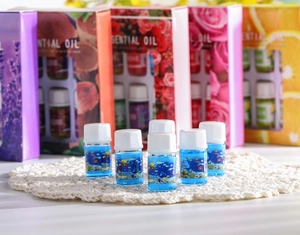 Detail of six 3ml water-soluble essential oil bottles on a white crochet mat with boxes
