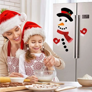 Christmas snowman magnet set with red scarf and gloves on a silver refrigerator door