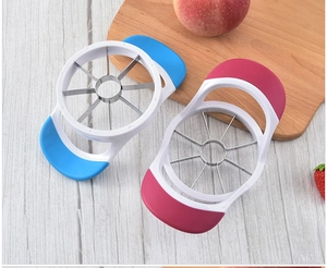 Detail of red and blue stainless steel apple slicers on a rustic wooden table surface