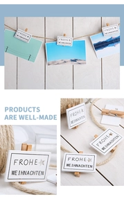 Close-up of wooden Christmas clips with Frohe Weihnachten text and star cutouts