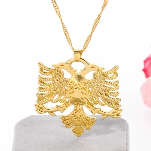 Vue détaillée du pendentif aigle doré sur un présentoir de bijoux en velours gris