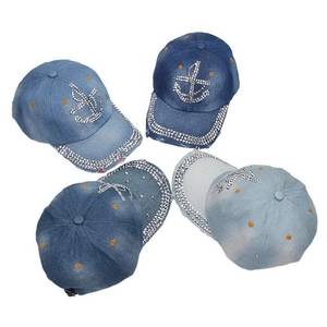 Detail view of denim baseball caps with rhinestone anchor designs in multiple washes