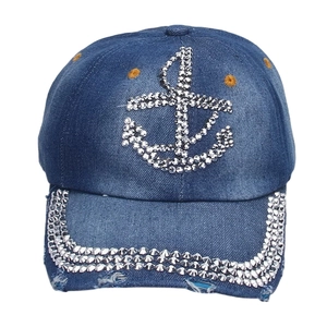 Detailed view of dark blue denim baseball cap featuring rhinestone anchor and studded brim
