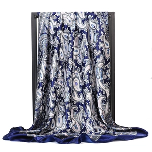 Detailed view of large navy blue and white paisley satin silk scarf on display