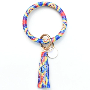 Λεπτομέρεια μπρελόκ tie-dye με δερμάτινη φούντα και χρυσό μεταλλικό δακτύλιο