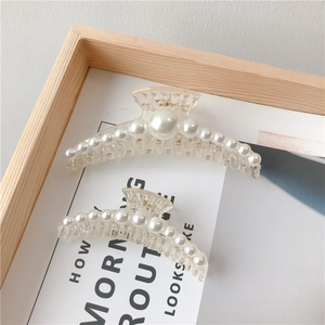 Close-up of clear acrylic hair claws in two sizes with elegant pearl edge embellishments