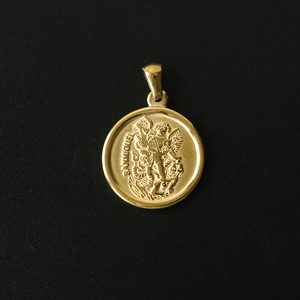 Detailed macro view of 18K gold plated San Miguel angel relief pendant on black background