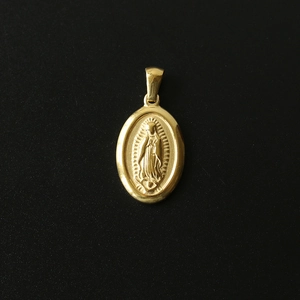 Macro shot of 18K gold plated Virgin Mary pendant with detailed embossed metal texture