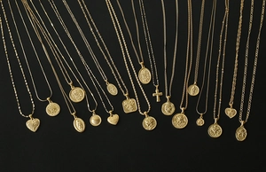 Close-up of vintage 18K gold plated titanium necklaces with heart and cross pendants