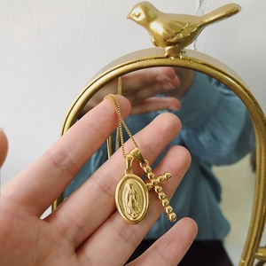 Detail of 18K gold plated titanium steel necklace with Virgin Mary and cross pendants