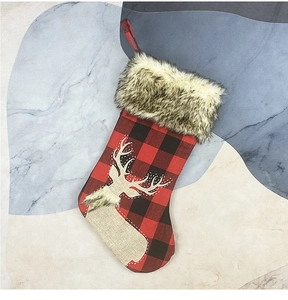 Detail of red and black buffalo plaid Christmas stocking with reindeer and plush trim