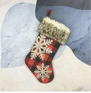 Detail of buffalo plaid Christmas stocking with snowflake applique and faux fur trim