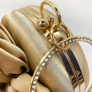 Elegant gold silk evening clutch bag with pleated texture and rhinestone ring handle