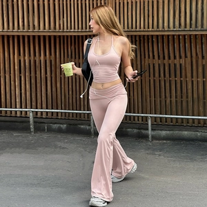 Detail of pink halter crop top and high-waisted flared trousers in elastic knit fabric