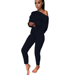 Dettaglio del set due pezzi in maglia nera con maglione con scollo a barca e pantaloni a coste