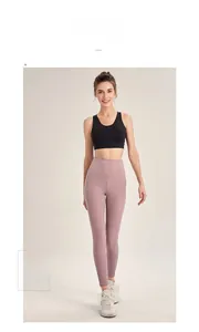 Close-up of pink high-waisted yoga leggings and black sports bra on a model