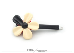 Détail d'une pince à cheveux minimaliste en acétate en forme de fleur bicolore chic