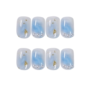 Blue ocean gradient press-on nails with marble texture, gold foil, and pearl accents