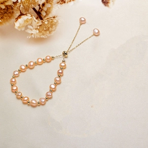 Pink freshwater pearl bracelet with gold beads and adjustable drawstring on silk