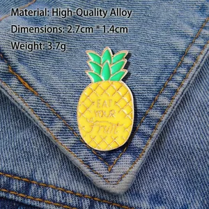 Creative pineapple enamel pin featuring Eat Your Fruit text on denim fabric, 2.7cm by 1.4cm