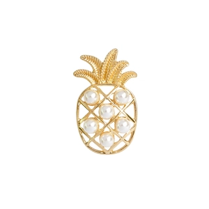 Golden pineapple brooch pin featuring elegant white pearls on a minimalist white background