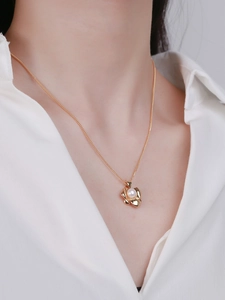 Elegant gold S925 sterling silver petal necklace with a round pearl on white shirt