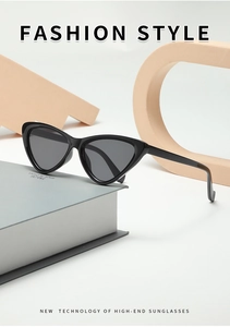 Detailed close-up of retro black cat-eye sunglasses on a minimalist geometric display