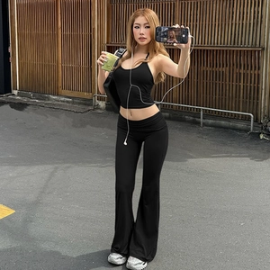 Close-up of black sleeveless crop top and high-waisted flared trousers set on model
