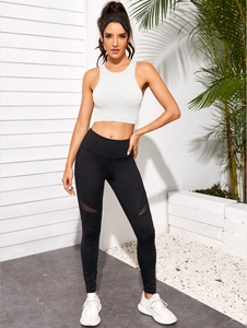 Détail du haut de sport côtelé blanc et du legging taille haute noir avec mesh